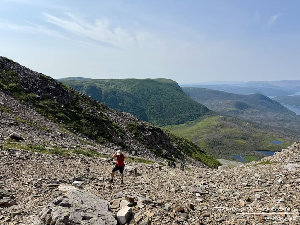 Ascension du Mont Gros-Morne dans un éboulis avec vue sur les collines