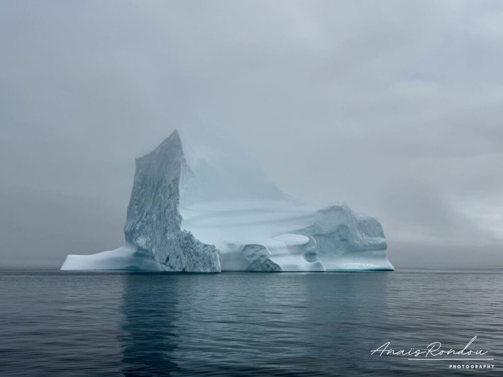 Iceberg en pleine mer sous un ciel nuageux près de Twillingate à Terre-Neuve