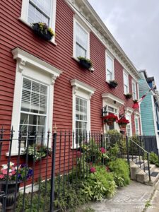 Maison rouge avec barrière noire et fleur à Saint John's