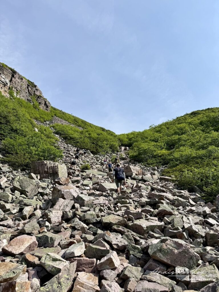 Personne marchant dans un éboulis de pierres au Mont Gros-Morne