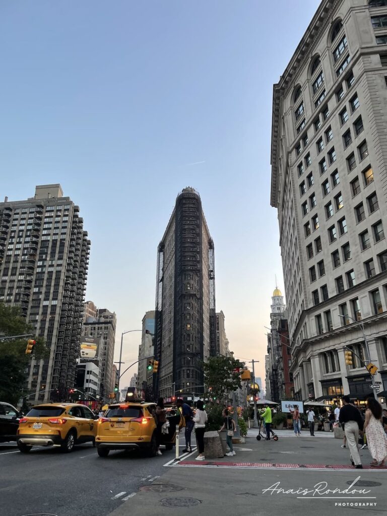 Flatiron Building dans les rues de New York Bâtiment triangulaire au milieu des rues new yorkaises nommé Flatiron Building