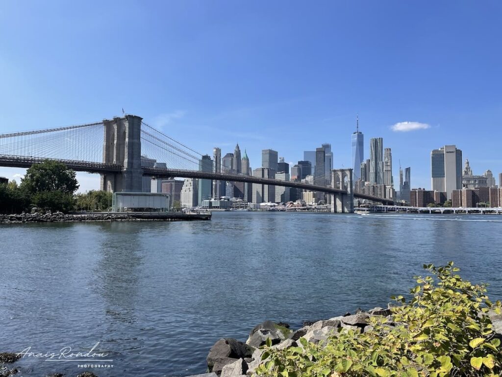 Pont de Brooklyn activité à faire Vue sur le pont de Brooklyn avec la skyline de New York en arrière plan sous un ciel bleu à voir