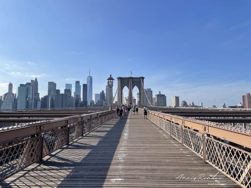 Traversée pont de Brooklyn New York Traversée à pied du pont de Brooklyn avec New York en fond sous un ciel bleu