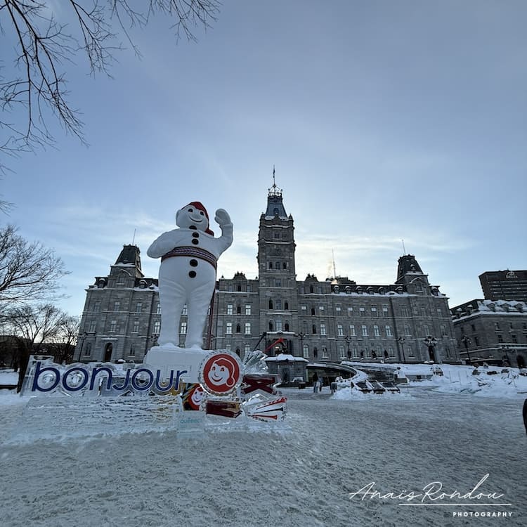 Carnaval Québec activité hiver Parlement de Québec avec la mascotte du carnaval de Québec devant