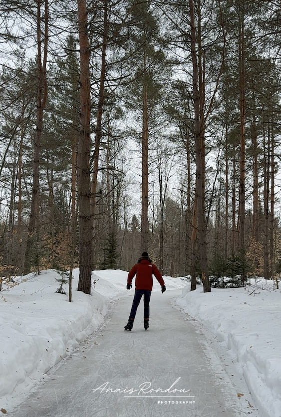 Patin activité d'hiver au Québec Personne qui patine sur un sentier glacé dans les bois au Domaine Enchanteur