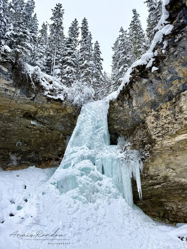 Chutes inférieurs de Troll Falls gelées au coeur de parois rocheuses à Kananaskis